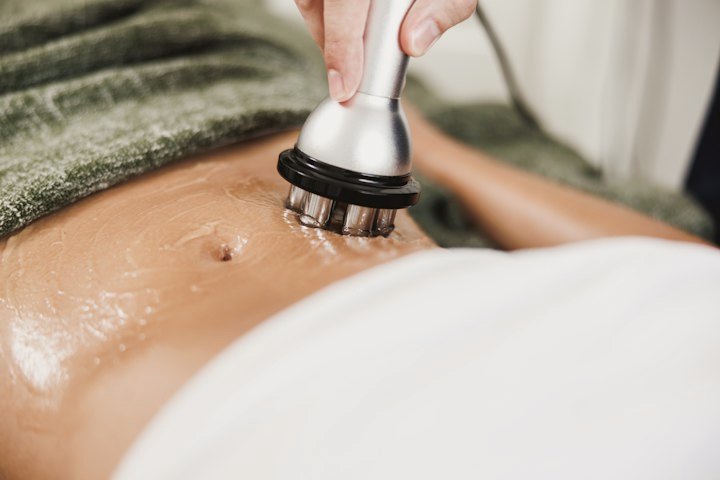 A body contouring device being used on the stomach